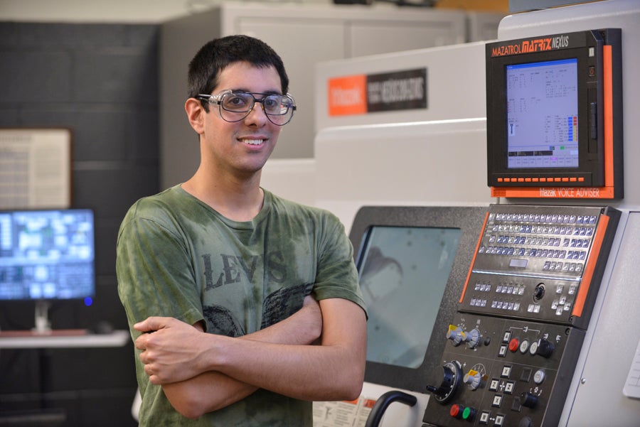 Odanis Rodriguez in front of a CNC controller