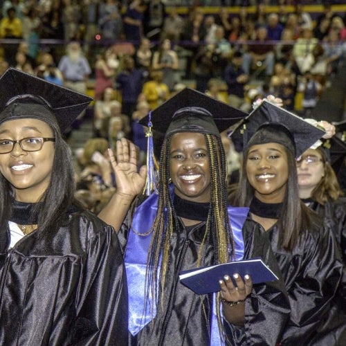 Grads smiling and waving