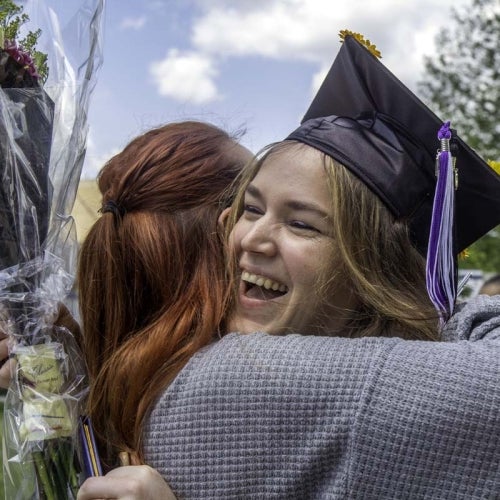 Graduate hugging family member